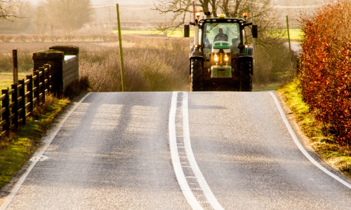 A tractor driving down a country road
